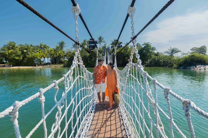 Guests enjoying a scenic walk across a bridge at Palawan Beach